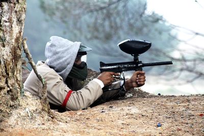 Side view of man aiming airsoft gun