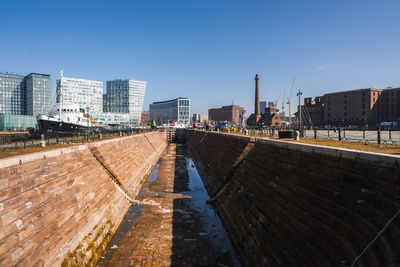 Buildings in city against clear blue sky