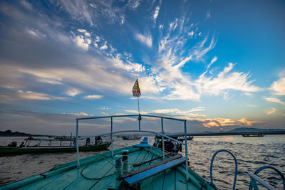 Fishing boat moored on sea against sky