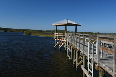 Gazebo by lake against clear sky