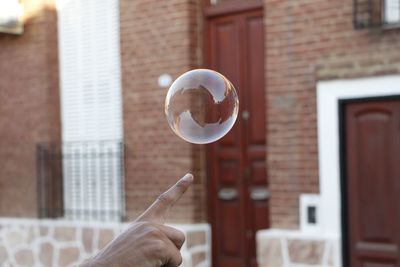 Cropped hand pointing against bubble