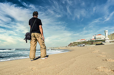 Man standing on beach against sky