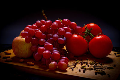 Close-up of fruits on table against black background