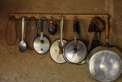 Kitchen utensils hanging from rack against wall