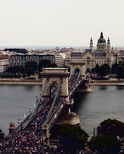 Bridge over river in city against clear sky