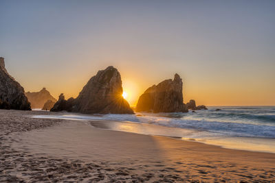 Beautiful sunset on a beach with sea stacks at the portuguese atlantic coast