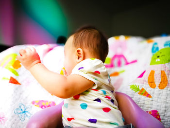 Close-up of cute baby boy on bed