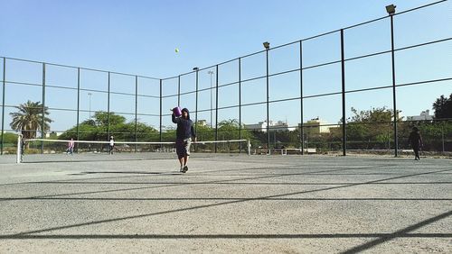 Man playing soccer in city against sky