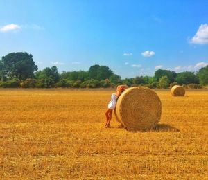 Hay bales on field against sky