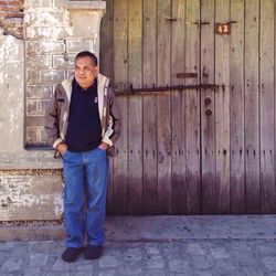 Portrait of teenage girl standing against wall