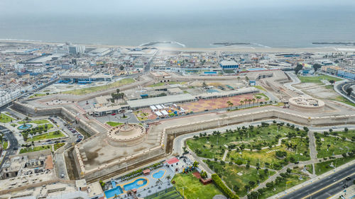 High angle view of city by sea against sky