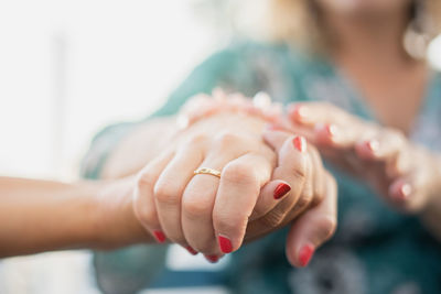 Midsection of woman holding hand of friend