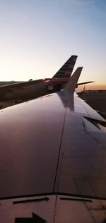 Airplane flying over sea against sky during sunset