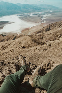 Low section of man relaxing on mountain