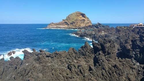 Panoramic view of sea against clear blue sky