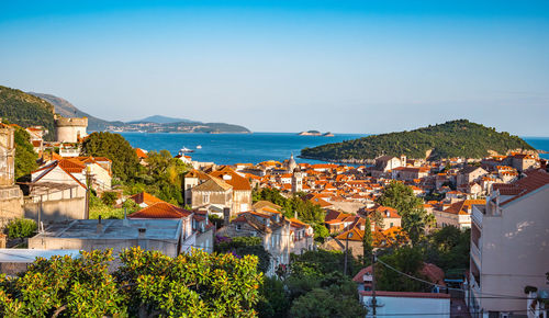 High angle view of townscape by sea against clear sky