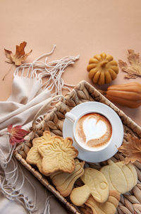 Autumn cozy composition. cup of coffee, cookies on tray, yellow leaves. autumn, fall concept. 