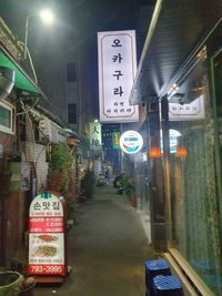 Road sign on street in city at night