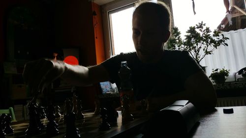 Young man sitting on table at home