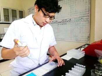 Mid adult man holding working in laboratory