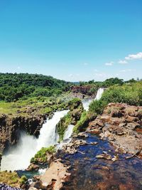 Scenic view of waterfall against sky