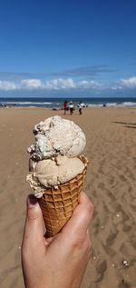 Person holding ice cream on beach