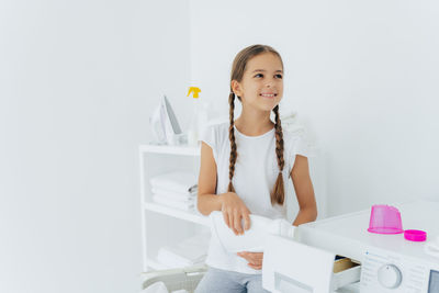 Smiling girl washing clothes