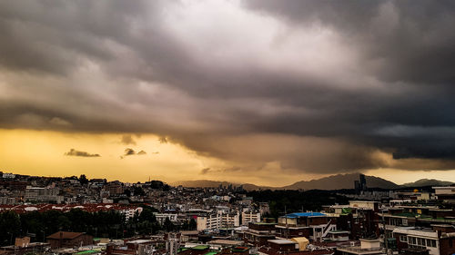 Aerial view of city against dramatic sky