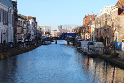 Canal amidst buildings against sky in city