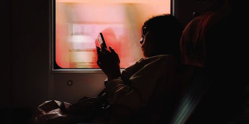 Side view portrait of woman using mobile phone