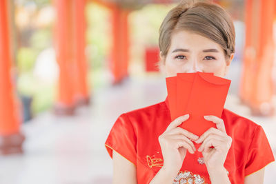 Portrait of woman holding red mask