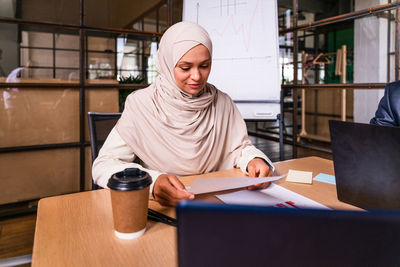 Portrait of young woman working at table