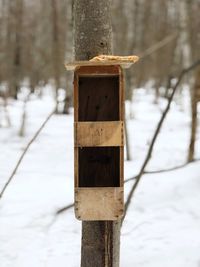 Close-up of wooden post on snow covered field