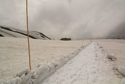 Scenic view of snow covered field against sky