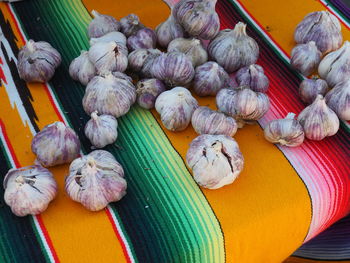 High angle view of garlic bulbs on chair on colorful market stall