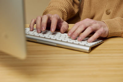 Midsection of woman using laptop on table