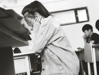 Woman sitting on chair by table