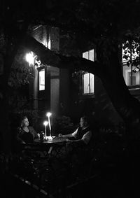 People sitting in illuminated building at night