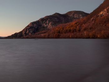 Scenic view of lake by mountains against sky