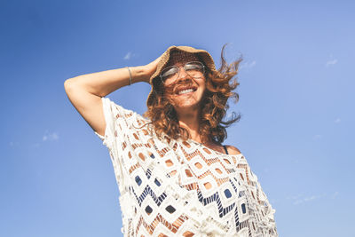 Low angle view of woman wearing hat against sky