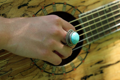 Cropped hand of young woman playing guitar