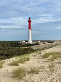 Lighthouse by sea against sky