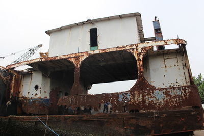 Low angle view of abandoned ship against sky