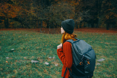 Rear view of person standing on field during autumn