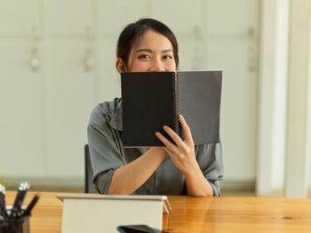 Portrait of a young woman sitting on table