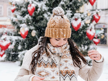 Woman standing against christmas tree