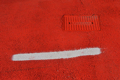 High angle view of white line text on red road