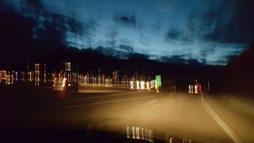 Illuminated trees against sky at night