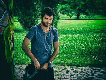 Portrait of young man standing in grass