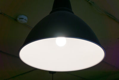 Low angle view of light bulb hanging on ceiling